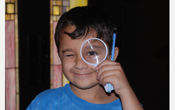 A boy tests a magnifying glass at the 