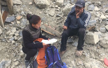 A woman research assistant interviews a quake survivor in Mustang District.