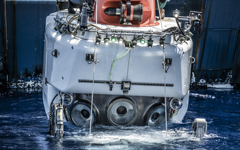 scientists look out from sphere in the sea