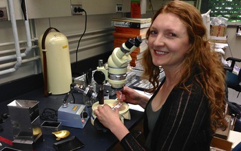 Researcher Summer Praetorius with a microscope in a lab