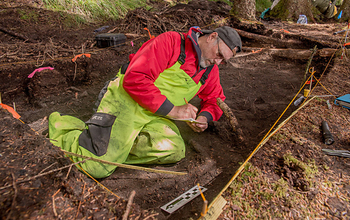 Dave McMahan at archeological site taking notes