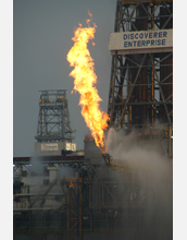 Natural gas collected from sea floor is flared at the surface by a drillship