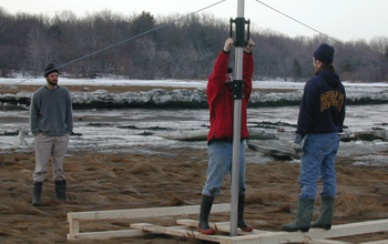 Scientists install a Sediment Elevation Tube in a salt marsh to observe the activity of microbes.
