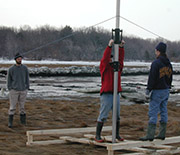 Scientists install a Sediment Elevation Tube in a salt marsh to observe the activity of microbes.