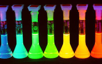 Samples showing quantum dot solutions emitting light at wavelengths across the rainbow.