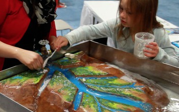 child  looking at a Mississippi river delat model