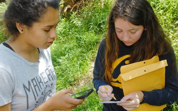 Two young women with smart phone and envelopes