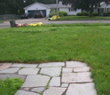 Photo of a U.S. suburban house with lawn garrage and cars parked outside