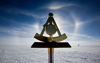 A sundog appears behind the 2011 geographic South Pole marker