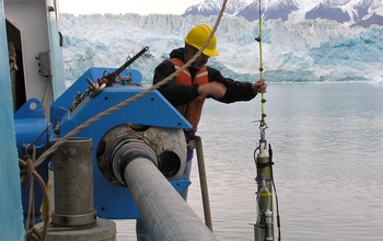 Scientist lowering an instrument in water