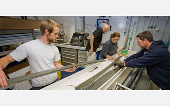 Photo of scientists splitting open retrieved sediment cores.