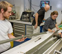 Photo of scientists splitting open retrieved sediment cores.