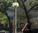 Artist rendering of man taking photo of an Array of Things node mounted on city streetlight pole