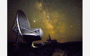 Antennas of the Allen Telescope Array (ATA) at night, with the Milky Way and Jupiter in the sky
