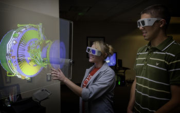 Students observe a 3-D projection of an aircraft engine