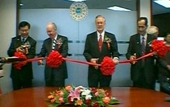 Four officials prepare to cut a red ribbon at the ribbon-cutting ceremony