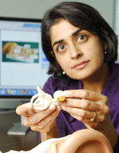 Pamela Bhati holding a cochlear implant