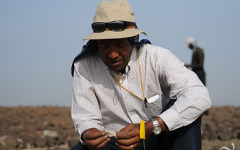 Photo of Yohannes Haile-Selassie holding a fossil fragment.