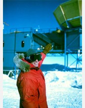 John Carlstrom, dressed in cold-weather gear, points to the DASI detector.