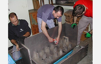 Research team members carefully craft the centrifuge sample chamber that holds the experiment.