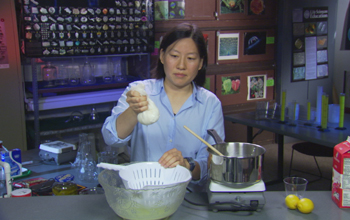 Photo of Julie Yu making fresh cheese from milk and lemon juice.