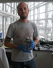 John Chmiola displays an electrochemical capacitor test cell in a home-built dry box.