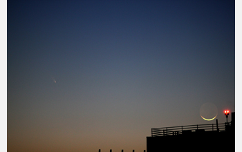 Comet PanSTARRS (left) and the waxing crescent moon (lower right) set over the Arlington, Va.