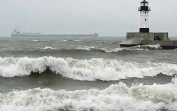 Lighthouse on a lake with freighter in distance