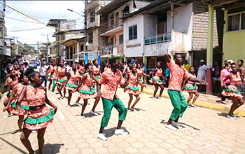 group of people dancing down a street