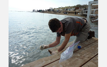 Photo of a scientist sampling Dead Sea water, which is some 12 times more saline than most seawater.