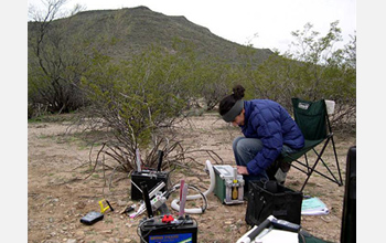 Photo of Kathy Gerst operating a device that measures photosynthetic gas exchange parameters.