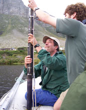 Photo of Curt Stager and Jay White retrieving a sediment core in a South African lake.