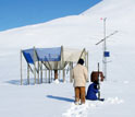 Photo of Alexander Kolodov and Mike LaDouceur examining an Arctic weathering station.