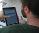 Photo of a researcher recording homeowner responses to questions on a tablet computer.