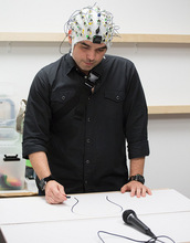 artist drawing while wearing EEG cap