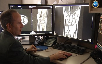 man sitting at desk examining xrays