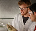 Photo of researchers examining a flask of cyanobacteria.