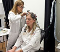 a young woman being prepared by a researcher for a brain imaging system.