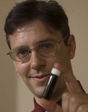 George Huber poses with a vial of green gasoline compounds.