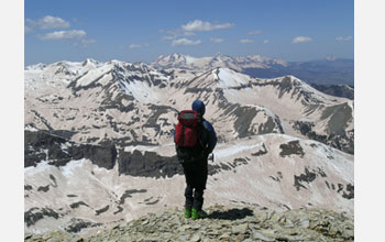 Photo of researcher viewing snow-capped mountains.