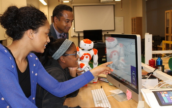 students and professor with robot and a computer