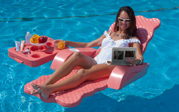 Photo of a woman in a lounge chair in a swimming pool watching an electrofluidic display.