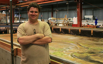 Photo of Christian Braudrick in front of model meandering river.