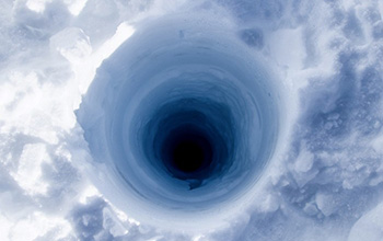 View looking down an ice coring borehole atop the Greenland ice sheet