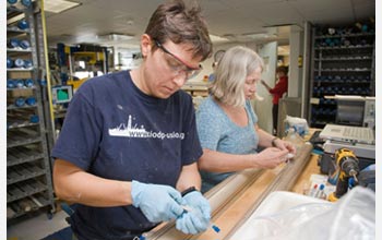 Photo of scientists working on a core sample from an IODP expedition.
