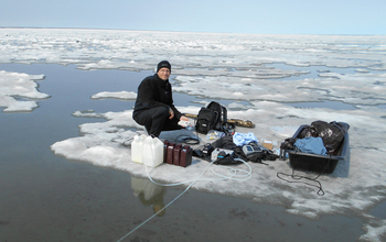 Researcher James McClelland sampling water during ice break-up in Kaktovik Lagoon, Alaska.