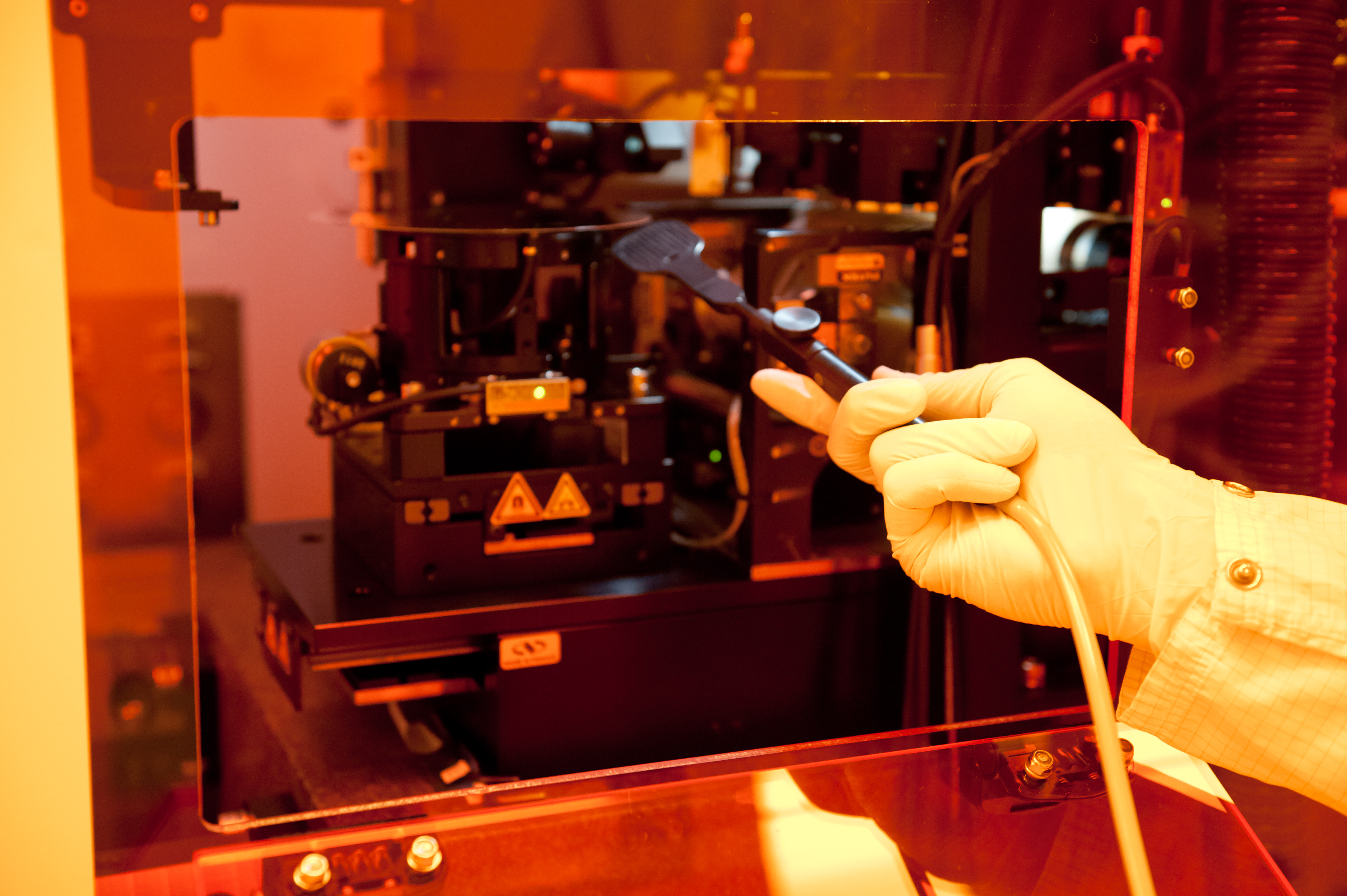 Photo of researcher loading a template used for nano-sculpting on plastic films.