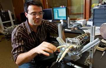 a University of Washington doctoral student interacting with a lifelike robotic hand.