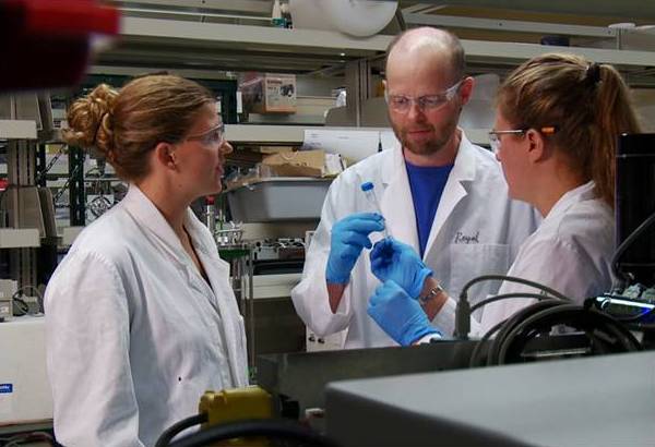 three interdisciplinary researchers discussing lab results.