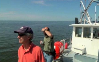 researchers on a boat looking at a lake